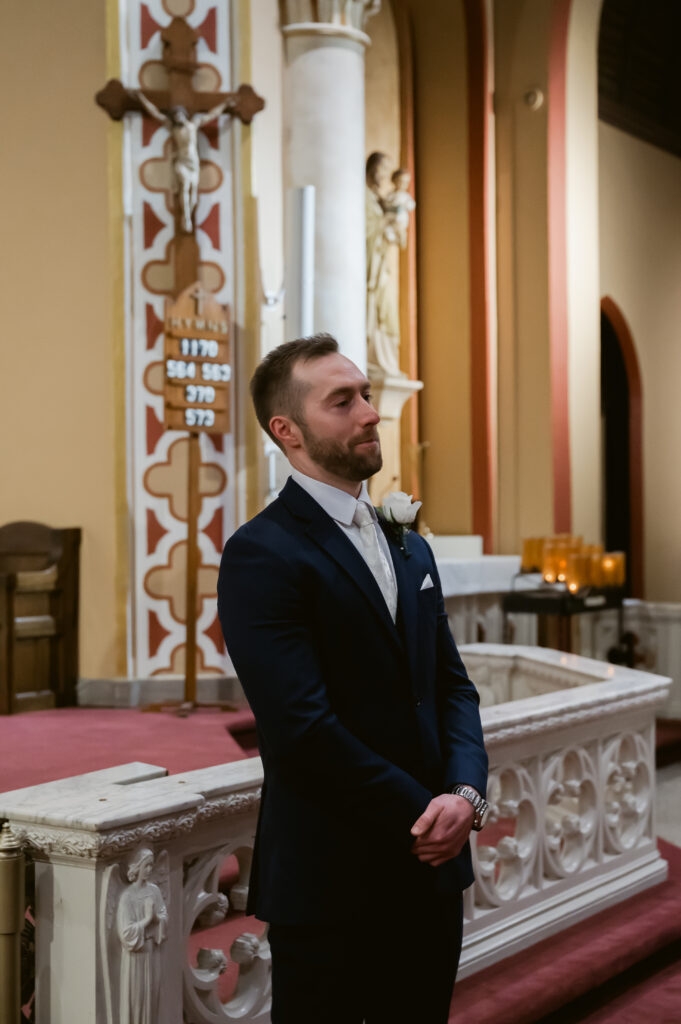 A Catholic Groom watches his Catholic Bride walk down the aisle during the Wedding Mass