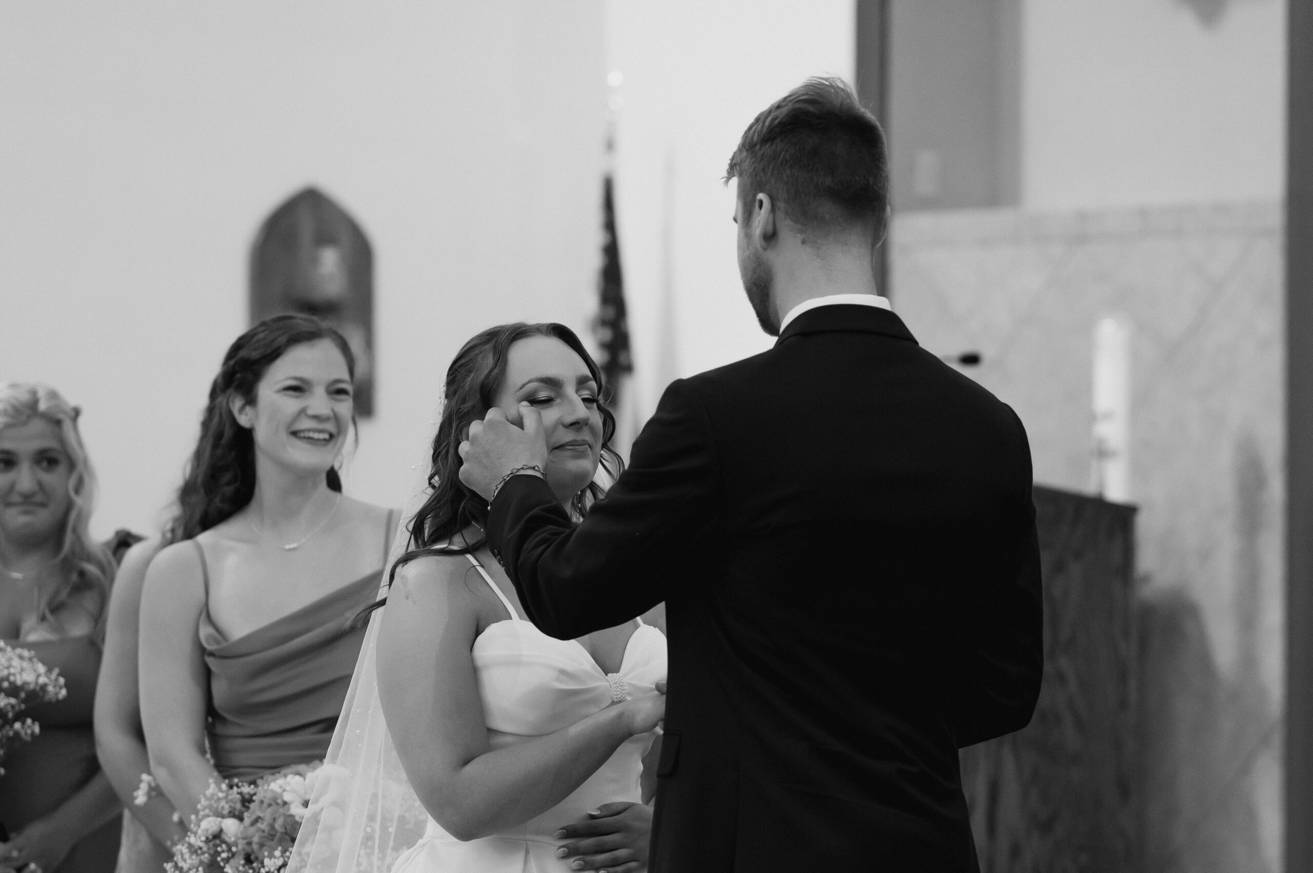 A Catholic Groom dries the tears of his Catholic Bride during the Catholic Wedding Mass in Ohio