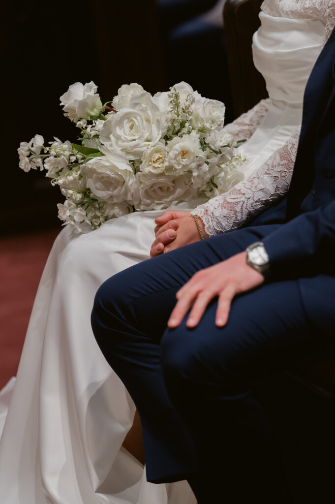 A Bride and Groom hold hands during their Catholic Wedding Mass in a Catholic Church in Ohio