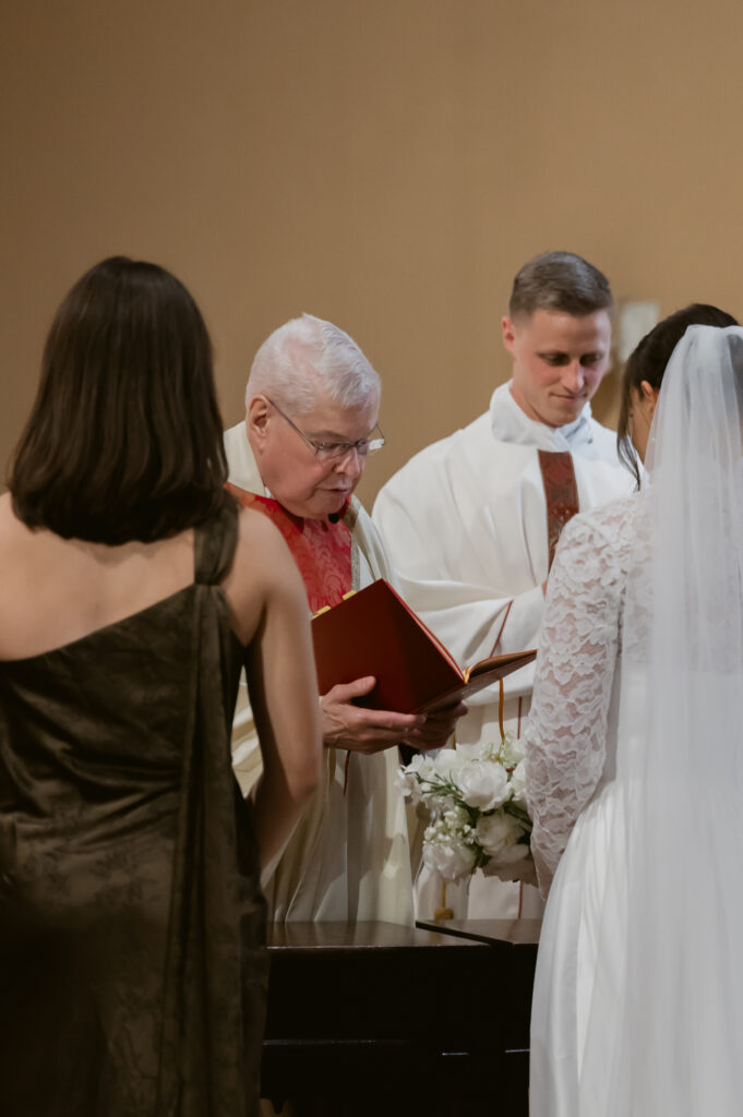 The Priest leading a Catholic Bride and Groom in their vows at their Catholic Wedding Mass in Catholic Church in Ohio 