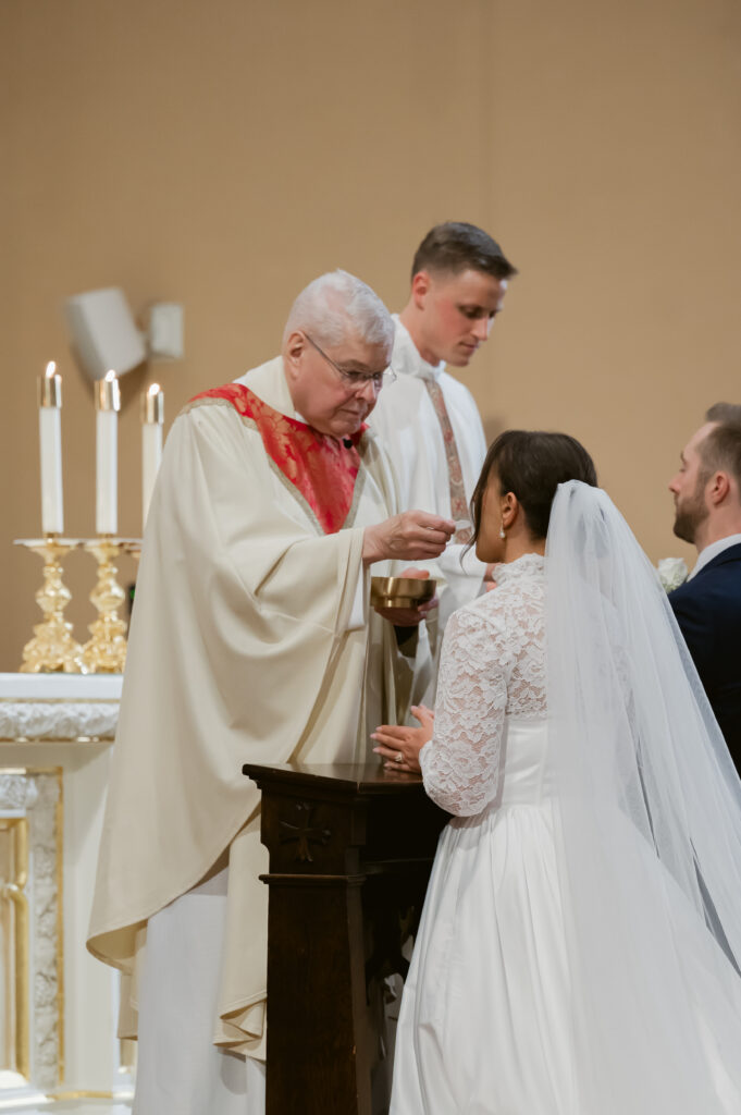 A Bride receives Holy Communion during her Catholic Wedding Mass in Ohio